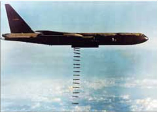 fotografia mostra um avião bombardeiro norte-americano B52 despejando bombas sobre determinada cidade no Vietnã do Norte, em dezembro de 1972